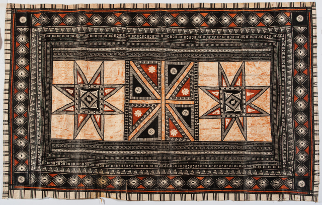 A cloth with complex geometric patterns, including linear patterns around the rectangular border, and three star-like shapes in a row at the center. The two outer shapes are almost identical the center shape a different form.