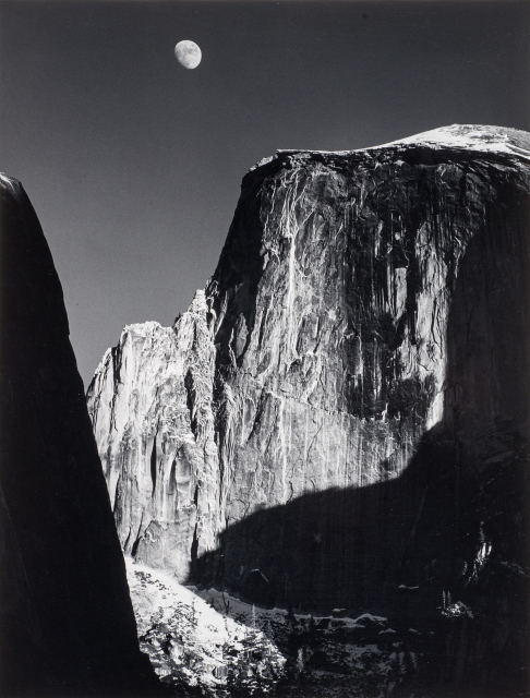 This image depicts a rock formation in Yosemite National Park with a gibbous moon in the sky above.